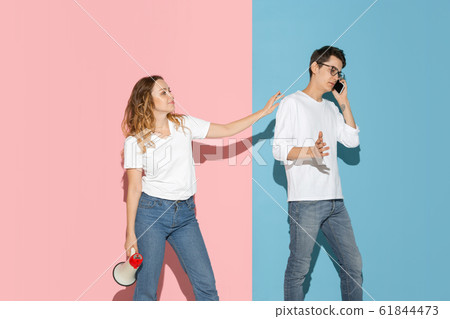 Young emotional man and woman on pink and blue background Young emotional man and woman on pink and blue background 61844473