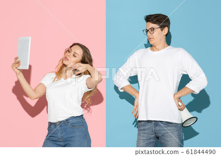 Young emotional man and woman on pink and blue background Young emotional man and woman on pink and blue background 61844490