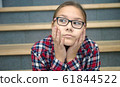 Girl is sitting on stairs and thinking 61844522