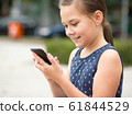 Little girl is using smartphone 61844529