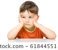 Sad little boy is sitting at table supporting his 61844551