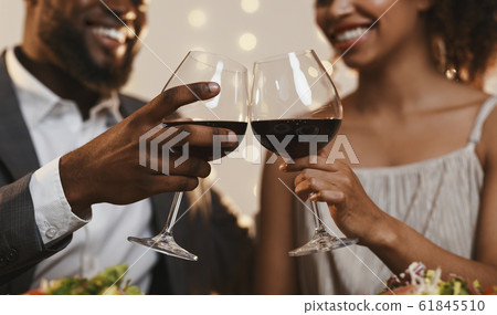 Close up of african couple toasting with red wine Close up of african couple toasting with red wine 61845510