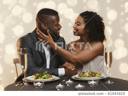 Attractive black woman touching her man, cuddling in restaurant Attractive black woman touching her man, cuddling in restaurant 61845820