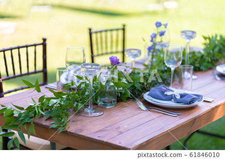 Beautifully decorated wooden table in a summer Beautifully decorated wooden table in a summer 61846010