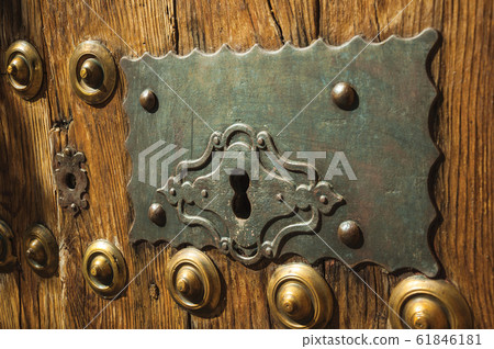 Bronze studs and wrought iron keyhole in an old door 61846181