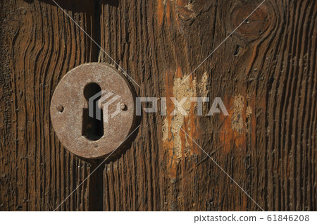 Iron keyhole in an old wooden door 61846208