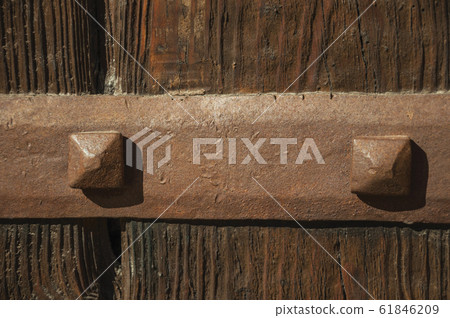 Iron hinge with studs in an old wooden door 61846209