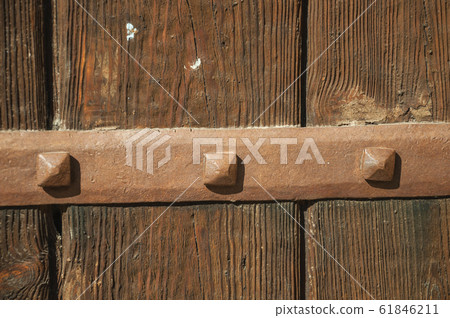 Iron hinge with studs in an old wooden door 61846211