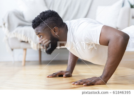 Young black man doing push ups, side view 61846395