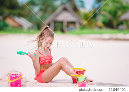 Adorable little girl playing with beach toys during tropical vacation 61846401