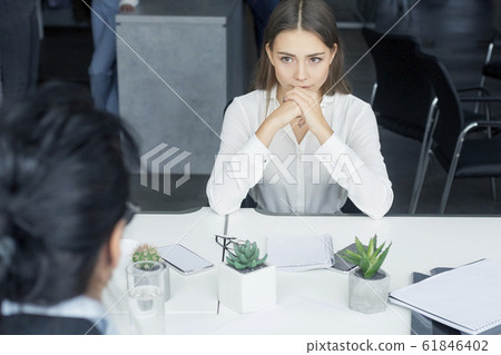 Nervous female applicant waiting for result at job interview Nervous female applicant waiting for result at job interview 61846402