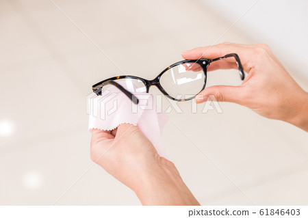 vision problems. closeup hands of a woman wiping her glasses vision problems. closeup hands of a woman wiping her glasses 61846403