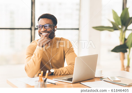 Happy black businessman in glasses listening to music Happy black businessman in glasses listening to music 61846405
