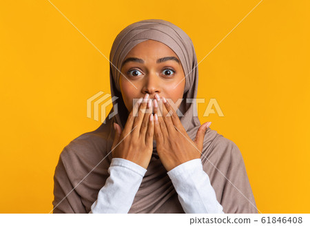 Shocked afro muslim woman in hijab covering her mouth with hands Shocked afro muslim woman in hijab covering her mouth with hands 61846408