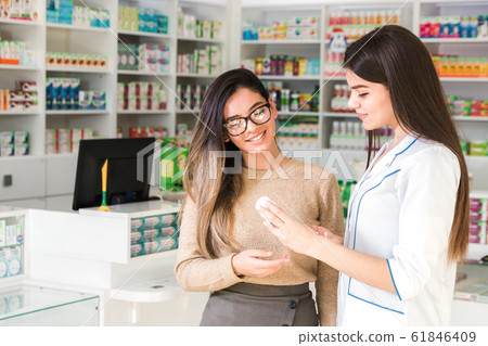 satisfied customer. professional consultation in pharmacy. confident pharmacist consults a client about a product in pharmacy satisfied customer. professional consultation in pharmacy. confident pharmacist consults a client about a product in pharmacy 61846409