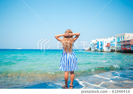 Adorable little girl at Little Venice the most popular tourist area on Mykonos island, Greece. Adorable little girl at Little Venice the most popular tourist area on Mykonos island, Greece. 61846419