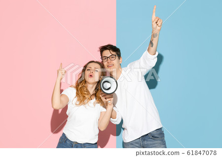 Young emotional man and woman on pink and blue background Young emotional man and woman on pink and blue background 61847078