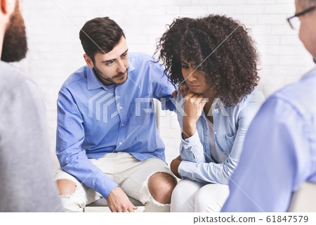 Supportive people comforting depressed black woman at group therapy meeting Supportive people comforting depressed black woman at group therapy meeting 61847579
