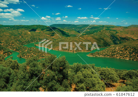 Tagus River running through a valley with hills at the Monfrague National Park Tagus River running through a valley with hills at the Monfrague National Park 61847612