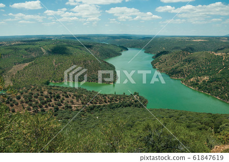 Tagus River running through a hilly valley at the Monfrague National Park Tagus River running through a hilly valley at the Monfrague National Park 61847619