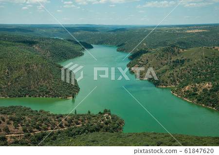 Tagus River running through a hilly valley at the Monfrague National Park Tagus River running through a hilly valley at the Monfrague National Park 61847620
