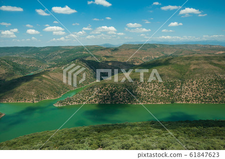Tagus River running through a valley with hills at the Monfrague National Park Tagus River running through a valley with hills at the Monfrague National Park 61847623