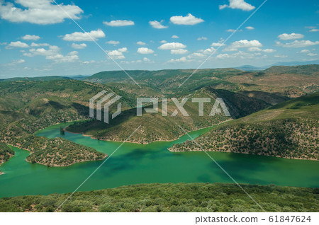 Tagus River running through a valley with hills at the Monfrague National Park Tagus River running through a valley with hills at the Monfrague National Park 61847624