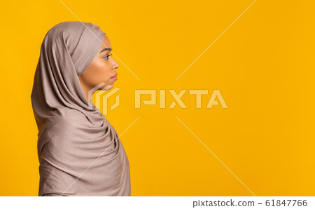 Profile portrait of black muslim woman in hijab over yellow background Profile portrait of black muslim woman in hijab over yellow background 61847766