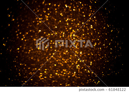 Dark background with golden bokeh in the shape of a heart. Dark background with golden bokeh in the shape of a heart. 61848122
