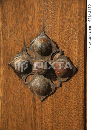Wrought iron stud in flower shape on an old wooden door Wrought iron stud in flower shape on an old wooden door 61848150