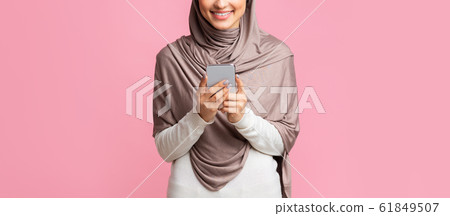 Unrecognizable arabic woman using smartphone, downloading application, messaging or browsing internet Unrecognizable arabic woman using smartphone, downloading application, messaging or browsing internet 61849507