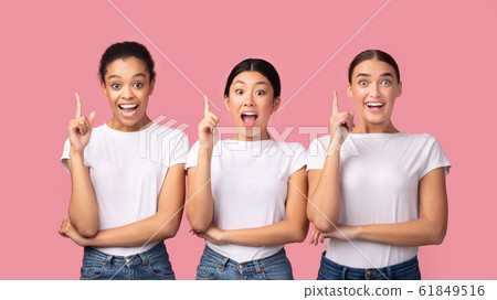 Three Millennial Girls Pointing Finger Up Standing, Pink Background, Panorama 61849516