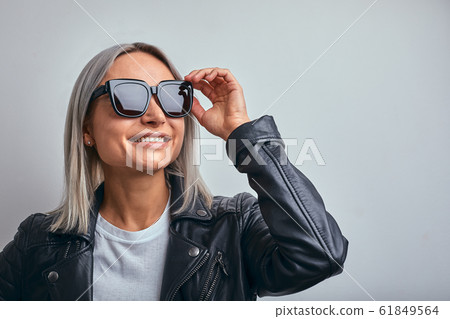 blonde sunglasses leather jacket on a gray background. copy space 61849564