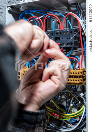 Electrician working on a residential electrical Electrician working on a residential electrical 61850049
