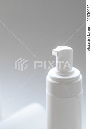 A closeup of foaming white plastic container for body and face care with a dispenser pump 61850085