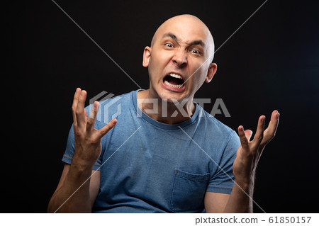 Photo of angry bald man in blue tee shirt Photo of angry bald man in blue tee shirt 61850157