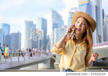 Young woman in calling on phone with friend during travel in Singapore Young woman in calling on phone with friend during travel in Singapore 61850204