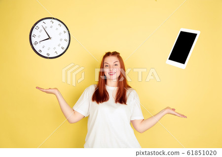 Caucasian young woman's portrait on yellow background, too much tasks 61851020