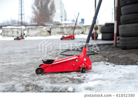 Red jack on tire service in winter. 61852380