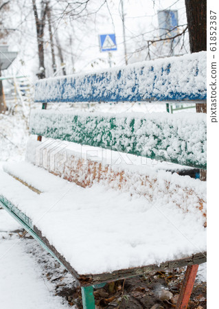 Benches for rest are covered with snow in the park 61852387