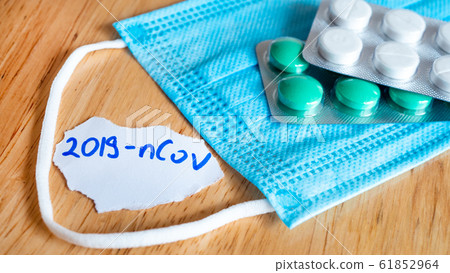 Medical face mask and pills with inscription Wuhan coronavirus 2019-nCoV 61852964