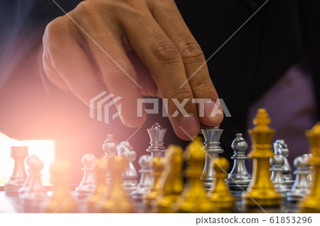 Chess game on chess board behind business man 61853296