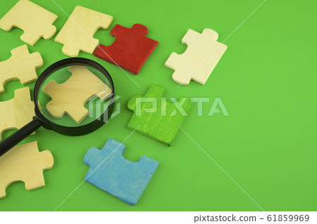 Jigsaw puzzle pieces with magnifying glass Jigsaw puzzle pieces with magnifying glass 61859969