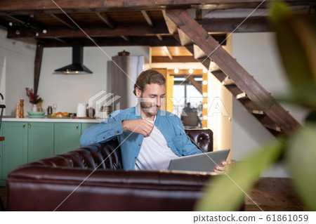 Emotional young man texting with his partner using a laptop 61861059