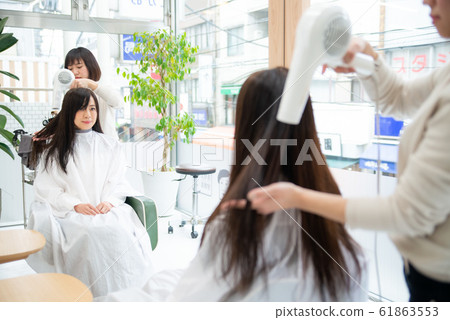 高級的女人在一家美容院做頭髮護理 高級的女人在一家美容院做頭髮護理 61863553