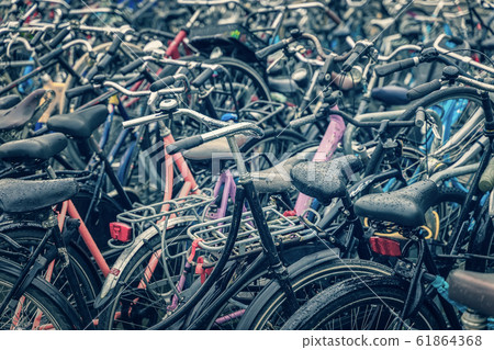 Bicycle parking with many bicycles, rayny day in Amsterdam 61864368
