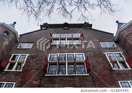 Old dutch hous facade, windows with opened red shutters, shooting from below Old dutch hous facade, windows with opened red shutters, shooting from below 61864385