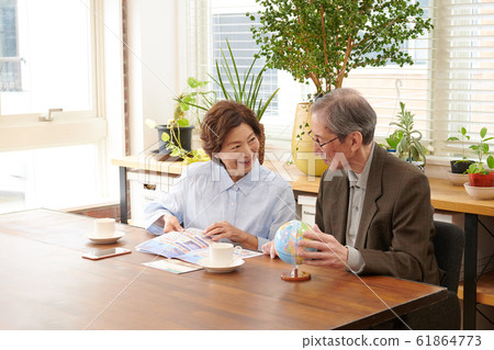 Senior couple consulting on travel while looking at brochure where to go 61864773