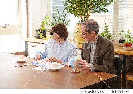 Senior couple consulting on travel while looking at brochure where to go Senior couple consulting on travel while looking at brochure where to go 61864775