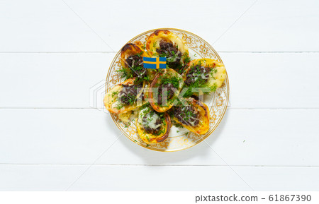 Stuffed potatoes. Swedish flag. Potatoes, minced meat, onion, carrot, cheese, garlic, dill. Swedish cuisine. Scandinavian food. Background Stuffed potatoes. Swedish flag. Potatoes, minced meat, onion, carrot, cheese, garlic, dill. Swedish cuisine. Scandinavian food. Background 61867390